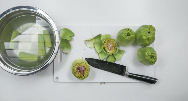 Quitar la mitad superior de las alcachofas, quitar las hojas duras del exterior y quitar el centro. Poner las alcachofas y los tallos en remojo en el agua con limón.