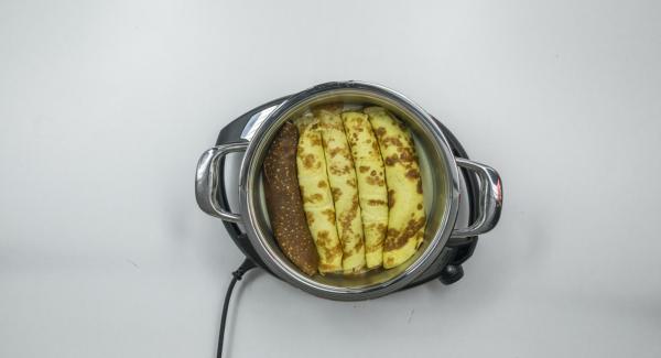 Colocar una olla en el Navigenio caliente. Verter la mitad de la salsa de queso e introducir las crepes rellenas. Agregar el resto de mezcla de zanahorias a la salsa restante y esparcir por encima de las crepes enrolladas.