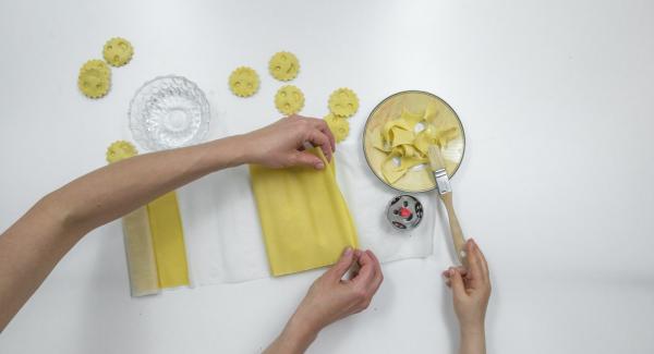 Cubrir con cuidado con la otra mitad de la masa, presionar bien alrededor del relleno y cortar los raviolis.