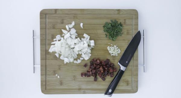 Pelar las patatas, cortarlas en dados y mezclarlas con el aceite de oliva. Pelar la cebolla y el diente de ajo y cortarlos también en dados. Cortar los chorizos en dados y picar las hojas del perejil.