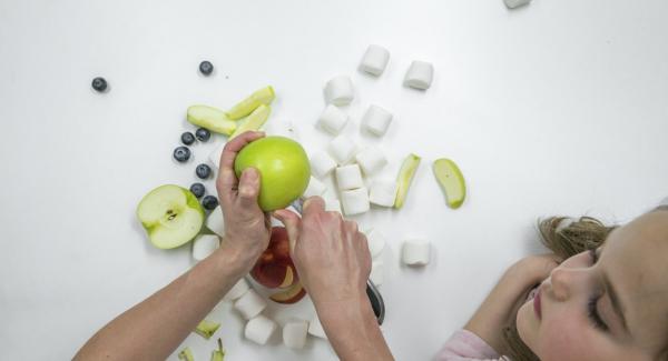 Si desea hacer que la cara graciosa de la rana sea una decoración, necesitará dos manzanas verdes, una manzana roja para la boca y dos malvaviscos y arándanos para los ojos.