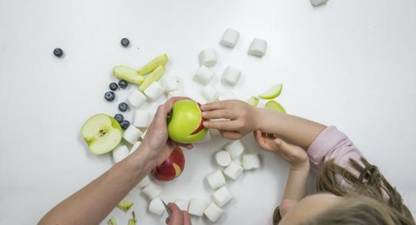 Si desea hacer que la cara graciosa de la rana sea una decoración, necesitará dos manzanas verdes, una manzana roja para la boca y dos malvaviscos y arándanos para los ojos.