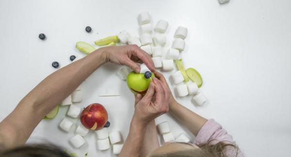 Si desea hacer que la cara graciosa de la rana sea una decoración, necesitará dos manzanas verdes, una manzana roja para la boca y dos malvaviscos y arándanos para los ojos.