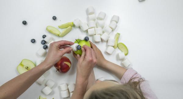 Si desea hacer que la cara graciosa de la rana sea una decoración, necesitará dos manzanas verdes, una manzana roja para la boca y dos malvaviscos y arándanos para los ojos.