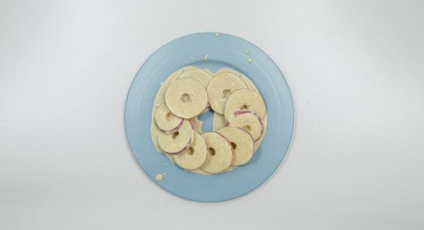 Sacar el corazón de 3 manzanas, cortarlas en aros de 0,5 cm de grosor. Espolvorear con harina y voltear la masa.