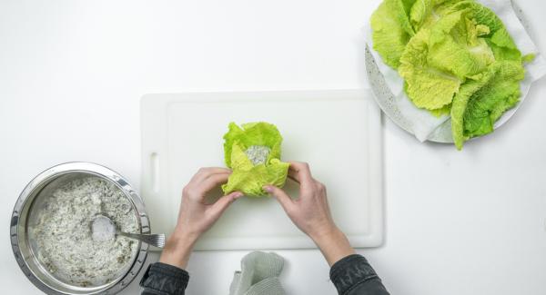 Colocar tres hojas de col de forma que se solapen ligeramente y poner el relleno de setas o de carne picada por encima, cerrar las hojas, enrollarlas y atarlas con hilo de cocina.