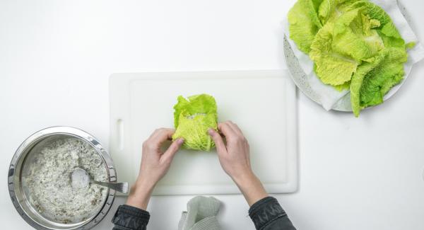 Colocar tres hojas de col de forma que se solapen ligeramente y poner el relleno de setas o de carne picada por encima, cerrar las hojas, enrollarlas y atarlas con hilo de cocina.