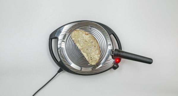 A continuación, reducir a baja temperatura (nivel 2)e introducir el pan en la oPan. En cuanto el pan se ablande, darle la vuelta y asar por el otro lado.