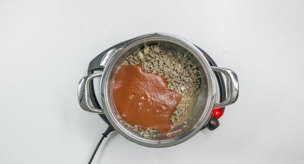 Cuando el Avisador (Audiotherm) emita un pitido al llegar a la ventana de “chuleta”, bajar temperatura de Navigenio (nivel 2) y añadir la carne picada con la mezcla de cebolla y sofreír. Agregar el maíz y los tomates colados, sazonar y mezcle bien.