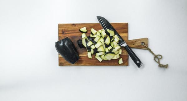 Pelar las cebollas y el ajo, cortar todo finamente en el Quick Cut y verterlo en la Gourmet. Limpiar las berenjenas y cortarlas en cubos (1 cm x 1 cm).