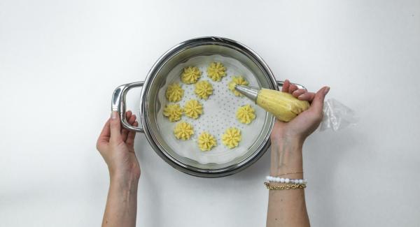 Mezclar las patatas con parmesano, huevo y especias y usando una manga hacer florecitas encima del papel de horno.