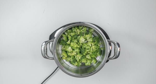 Introducir los dados de patata sin escurrir en una olla y colocar el brócoli en el Accesorio Súper-Vapor.