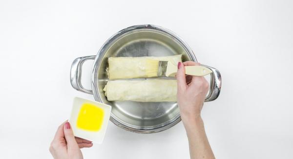 Hacer el segundo rollito del mismo modo con los ingredientes restantes. Untar los dos rollitos con la mantequilla restante..