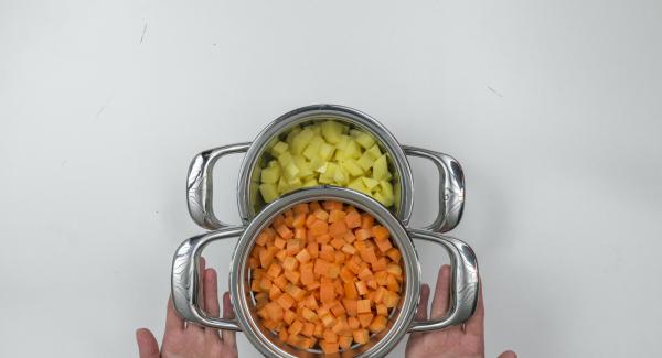 Colocar los cubos de patata con el agua del lavado en una olla y colocar las zanahorias en un accesorio super-vapor sobre ella.