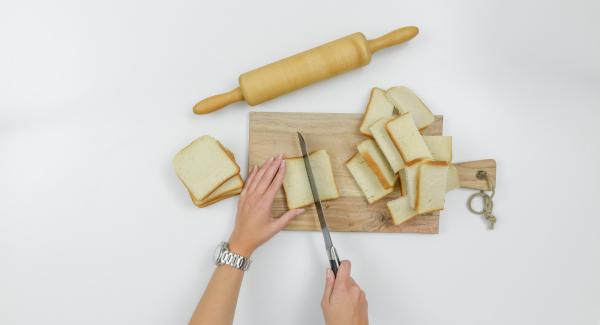 Cortar las rebanadas de pan por la mitad. Estirarlas con un rodillo.