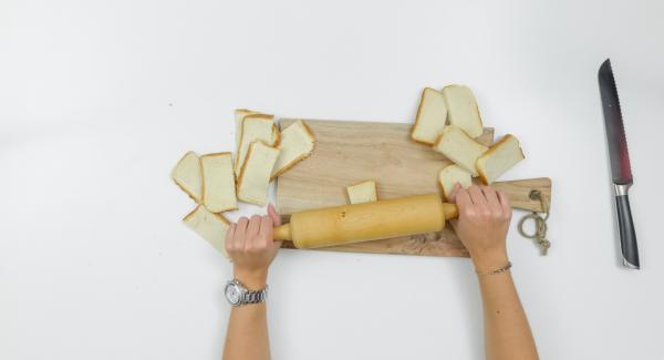 Cortar las rebanadas de pan por la mitad. Estirarlas con un rodillo.