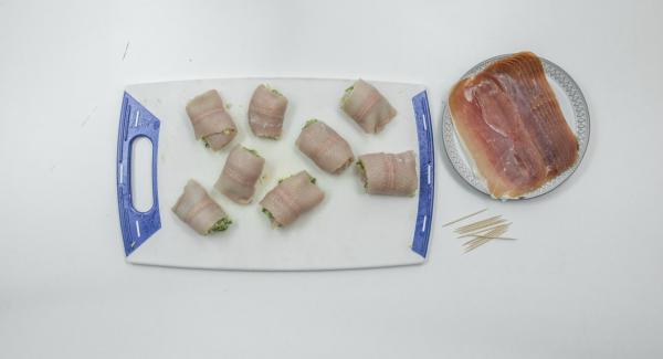 Mezclarlos con la mantequilla de almendra y sazonar con sal y pimienta. Untar con la mezcla la parte interior de los filetes de trucha y enrollarlos. Envolver con una loncha de jamón y pinchar el rollito con una brocheta.