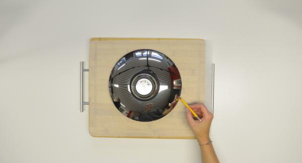 Con una tapa de 24 cm, recortar un círculo de papel para hornear.