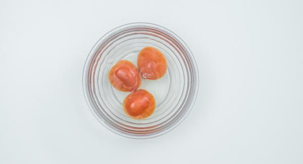 Escaldar los tomates en agua hirviendo, pelarlos y cortarlos en dados pequeños.