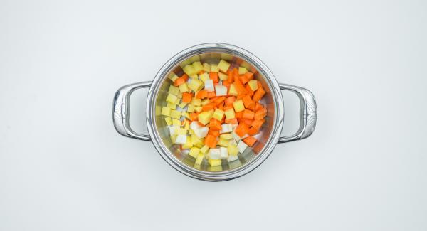 Introducir los dados de patata, zanahoria y nabo en la olla, sin escurrir, añadir los anillos de puerro y los dados de tomate.