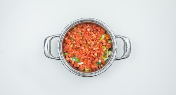 Introducir los dados de patata, zanahoria y nabo en la olla, sin escurrir, añadir los anillos de puerro y los dados de tomate.
