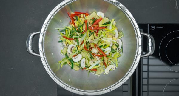 En el mismo Wok freír las verduras sin dejar de remover, añadir de nuevo la carne y sazonar con sal y pimienta.