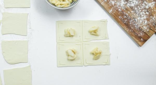 Poner unos dados de pera en el centro y doblar los bordes de la masa sobre las peras como una flor y presionarlas un poco (ver foto).