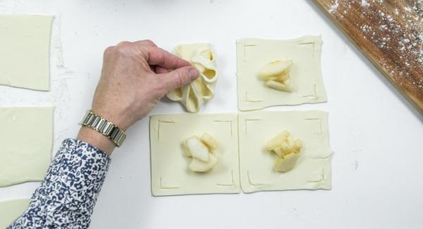 Poner unos dados de pera en el centro y doblar los bordes de la masa sobre las peras como una flor y presionarlas un poco (ver foto).