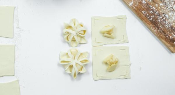 Poner unos dados de pera en el centro y doblar los bordes de la masa sobre las peras como una flor y presionarlas un poco (ver foto).