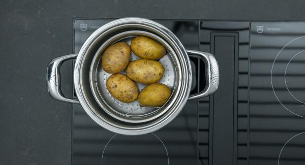 Verter una taza de agua en una olla. Lavar bien las patatas y colocarlas en la Softiera, introducir en la olla y tapar con la con la Tapa Rápida (Secuquick Softline).