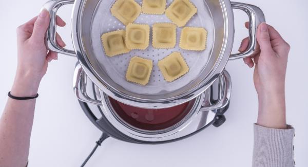 Verter agua (unos 100 ml) y la salsa de tomate en una olla.	Añadir los raviolis en el Accesorio Súper-Vapor con papel de horno, colocarlo sobre la olla y tapar con la Tapa Súper-Vapor (EasyQuick) con un aro de sellado de 20 cm.