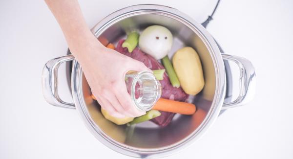 Lavar y pelar las cebollas, las zanahorias y las patatas. Clavar los clavos en las cebollas peladas y lavar las ramas de apio. Introducir la carne, las verduras y un vaso de agua en la olla.
