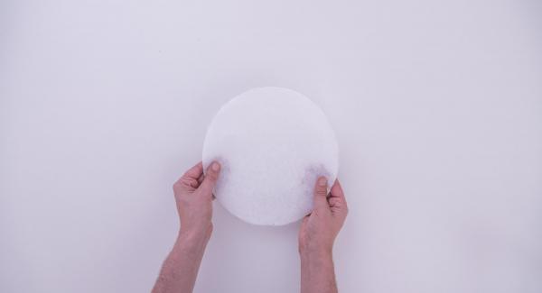 Extender el hojaldre en forma de círculo con un diámetro de unos 30 cm. Cortar un trozo de papel de horno del mismo diámetro.