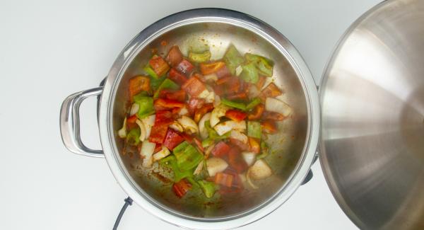 Cuando el Avisador (Audiotherm) emita un pitido al llegar a la ventana de “chuleta”, bajar temperatura de Navigenio (nivel 2) y verter el aceite, el ajo, la cebolla, los pimientos, la salsa de tomate y la pulpa de choricero. Remover y tapar.