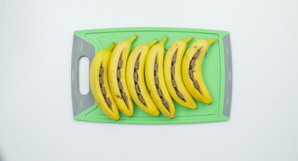 Lavar y secar bien los plátanos sin pelarlos. Hacer un corte a lo largo, a los plátanos con un cuchillo lo suficientemente profundo para rellenarlo con el chocolate. (el chocolate no debe sobresalir de  la abertura).