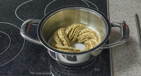 Poner la trenza en la olla. Colocar la olla en el fuego a temperatura baja. Colocar el Navigenio en modo de horno (poniéndolo invertido encima de la olla) y ajustar a temperatura baja. Cuando el Navigenio parpadee en rojo/azul, introducir 25 minutos en el Avisador (Audiotherm) y hornear.