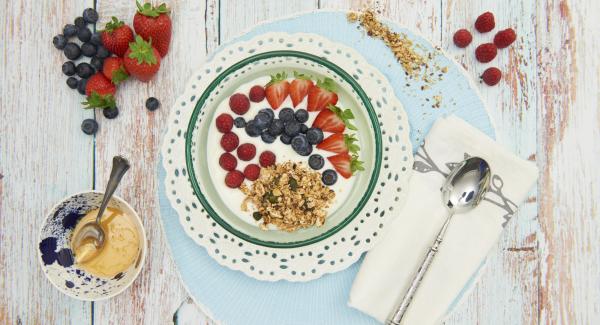 Mezclar el yogur con el muesli crujiente y decorar con los frutos rojos