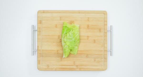 Extender la mezcla de carne picada sobre las hojas de repollo y enrollarlas, fijarlas con hilo de cocina.