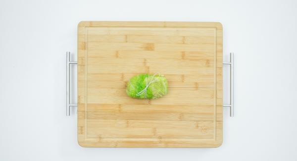 Extender la mezcla de carne picada sobre las hojas de repollo y enrollarlas, fijarlas con hilo de cocina.