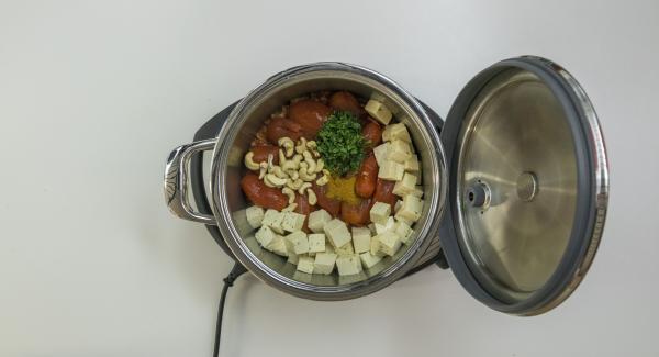 Añadir los tomates, el Garam Masala, los anacardos y la menta. Añadir también el tofu.