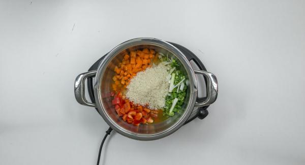Poner las verduras, los aros de cebolleta con arroz y el caldo en una olla.