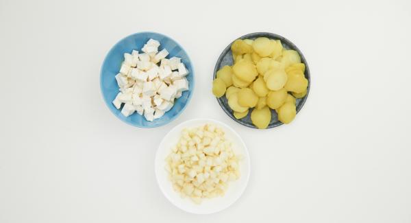 Cortar las patatas en rodajas. Pelar, desgranar y picar finamente las peras. Cortar el queso en dados pequeños y rociar con miel.
