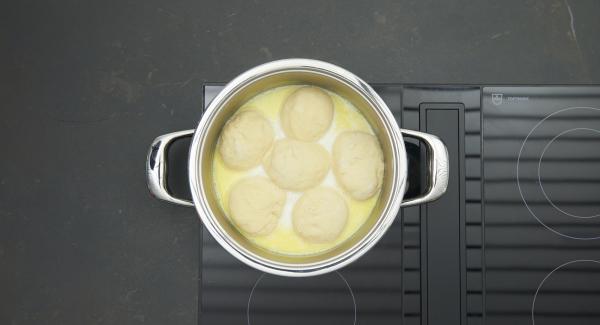 Poner los bollitos de levadura en la olla y tapar. Cocinar unos 25 minutos a fuego lento.