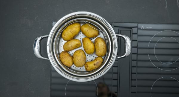 Añadir la salsa de tomate. Colocar las patatas en la Softiera,  introducir en la olla y tapar con la Tapa Rápida (Secuquick Softline). Ajustar el fuego a temperatura baja cocinar en el símbolo de "soft "durante aproximadamente 10 minutos con el Avisador (Audiotherm).