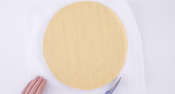 Trabajar la masa quebrada, extenderla y colocarla en el interior de la olla de 24 cm sobre un disco de papel de hornear ligeramente más grande que el fondo de la olla.