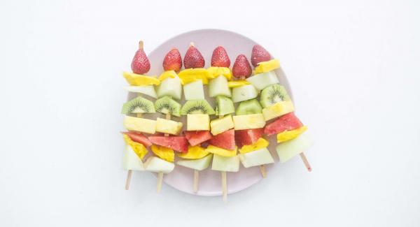 Pelar la fruta y cortarla en dados grandes. Insertar la fruta en una brocheta alternando las piezas y acabando con el fresón.