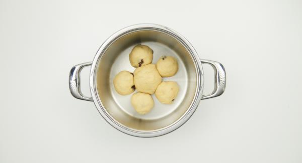 Colocar la bola de masa grande en el centro de la olla, colocar las bolas pequeñas alrededor. Pintar con yema de huevo batida. Espolvorear con láminas de almendras y azúcar.