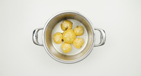 Colocar la bola de masa grande en el centro de la olla, colocar las bolas pequeñas alrededor. Pintar con yema de huevo batida. Espolvorear con láminas de almendras y azúcar.