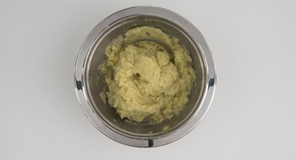 Colocar las patatas cocidas en un recipiente Combi y triturarlas con un tenedor. Añadir unos 100 g de queso parmesano, el perejil picado, la yema de huevo, sal, pimienta. Mezclar bien. Incorporar los dados de jamón.