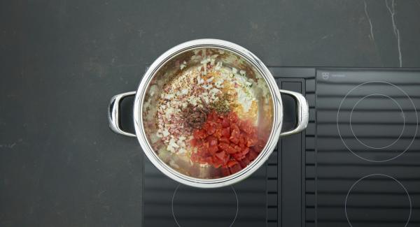 Sofreir las cebollas y el ajo sin dejar de remover. Añadir los tomates cortados a dados, las alcaparras y las anchoas. Ajustar el fuego a temperatura máxima, calentar la sartén  hasta la ventana de “zanahoria”, bajar temperatura y cocinar 3 minutos con el Avisador (Audiotherm).